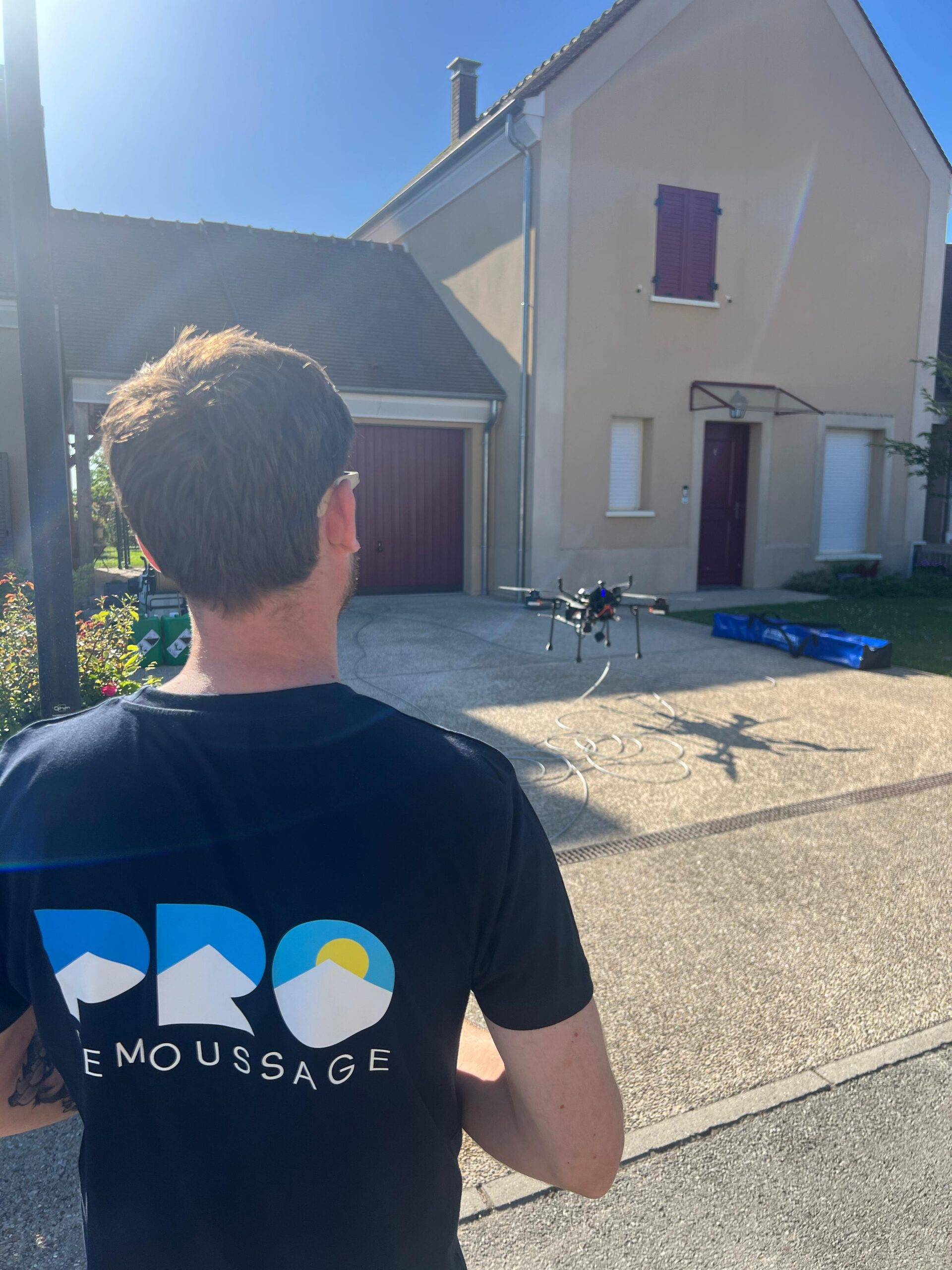 Xavier pilote son drone pour un démoussage de toiture